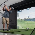 Golfer using a Carl’s Place DIY simulator enclosure in a garage